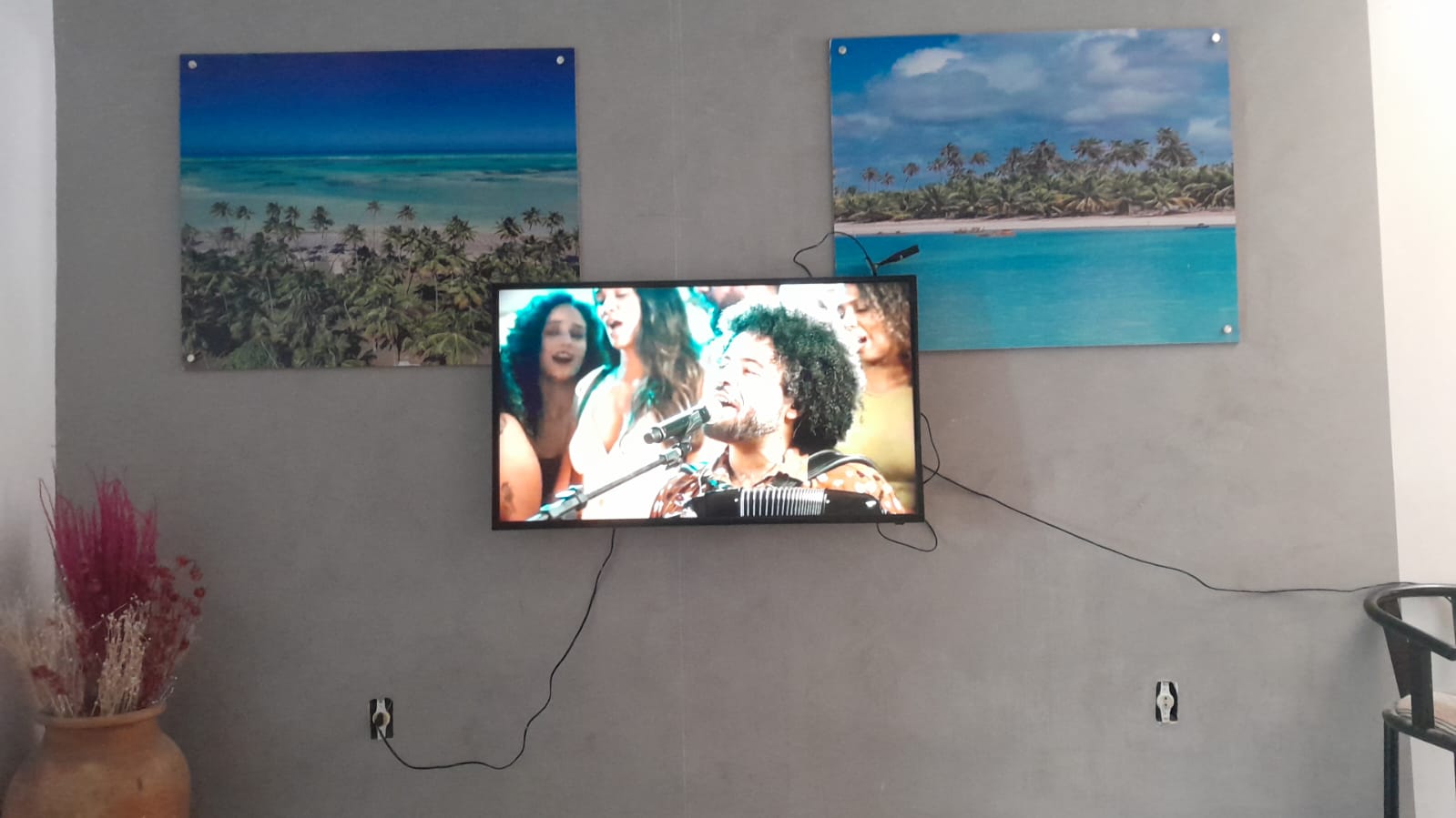 Área de convivência com TV e quadros de praia